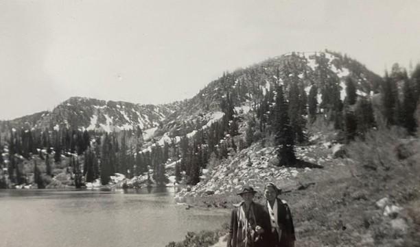 Two girl scouts posing in front of Lake Brimhall and the Wasatch Mountain Range.