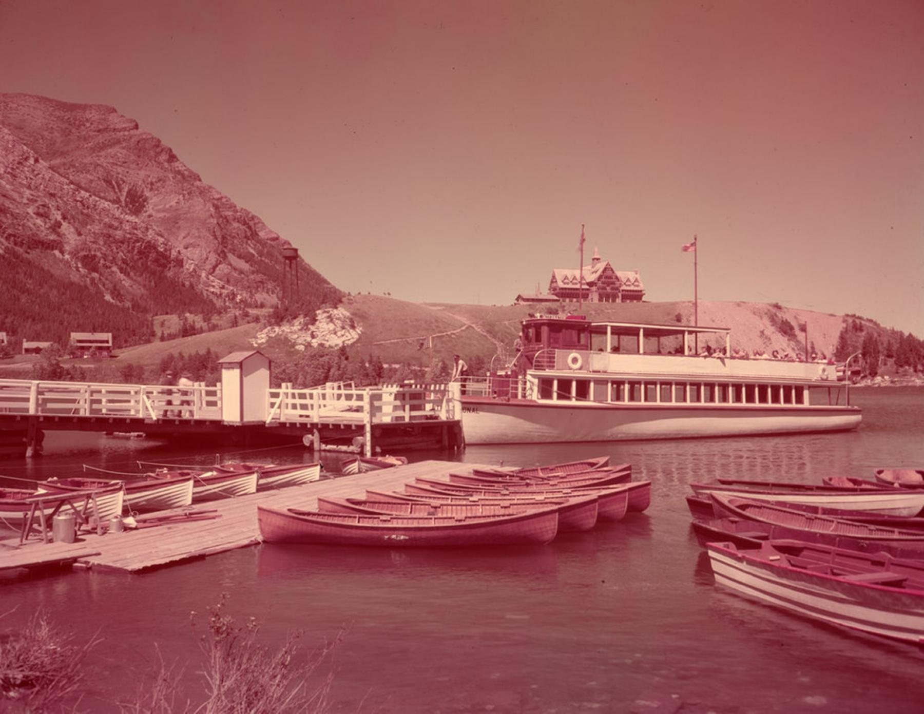 The International docked with passengers at the Waterton Townsite with the Prince of Wales Hotel in the background to the right, ca. 1940-1965