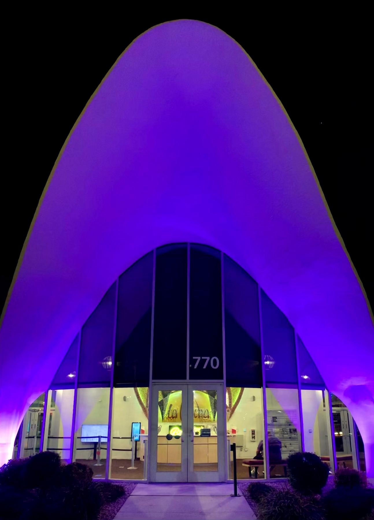 The glass front doors of the La Concha Lobby at night